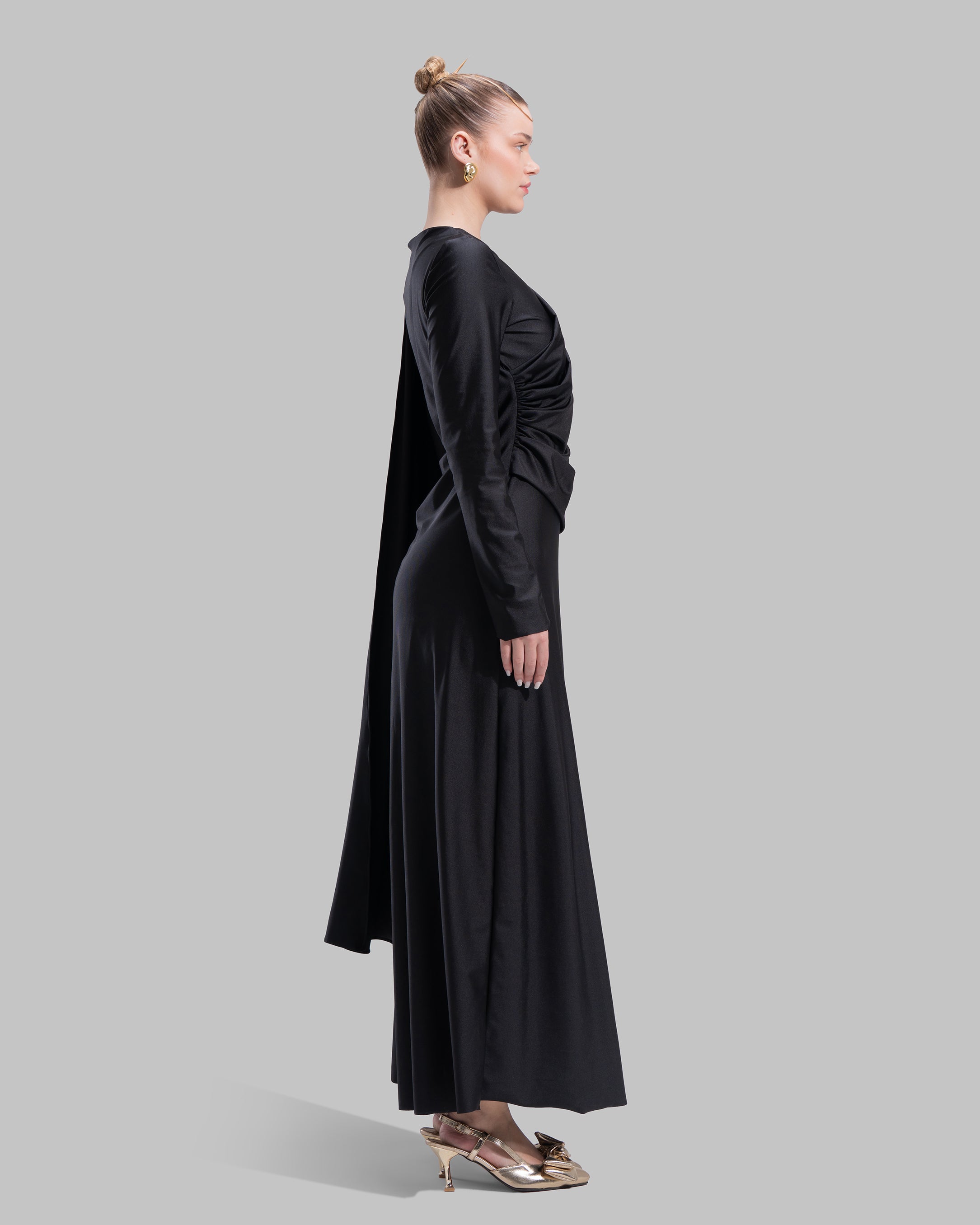 Long draped dress with a round neckline and asymmetrical overlay detail.