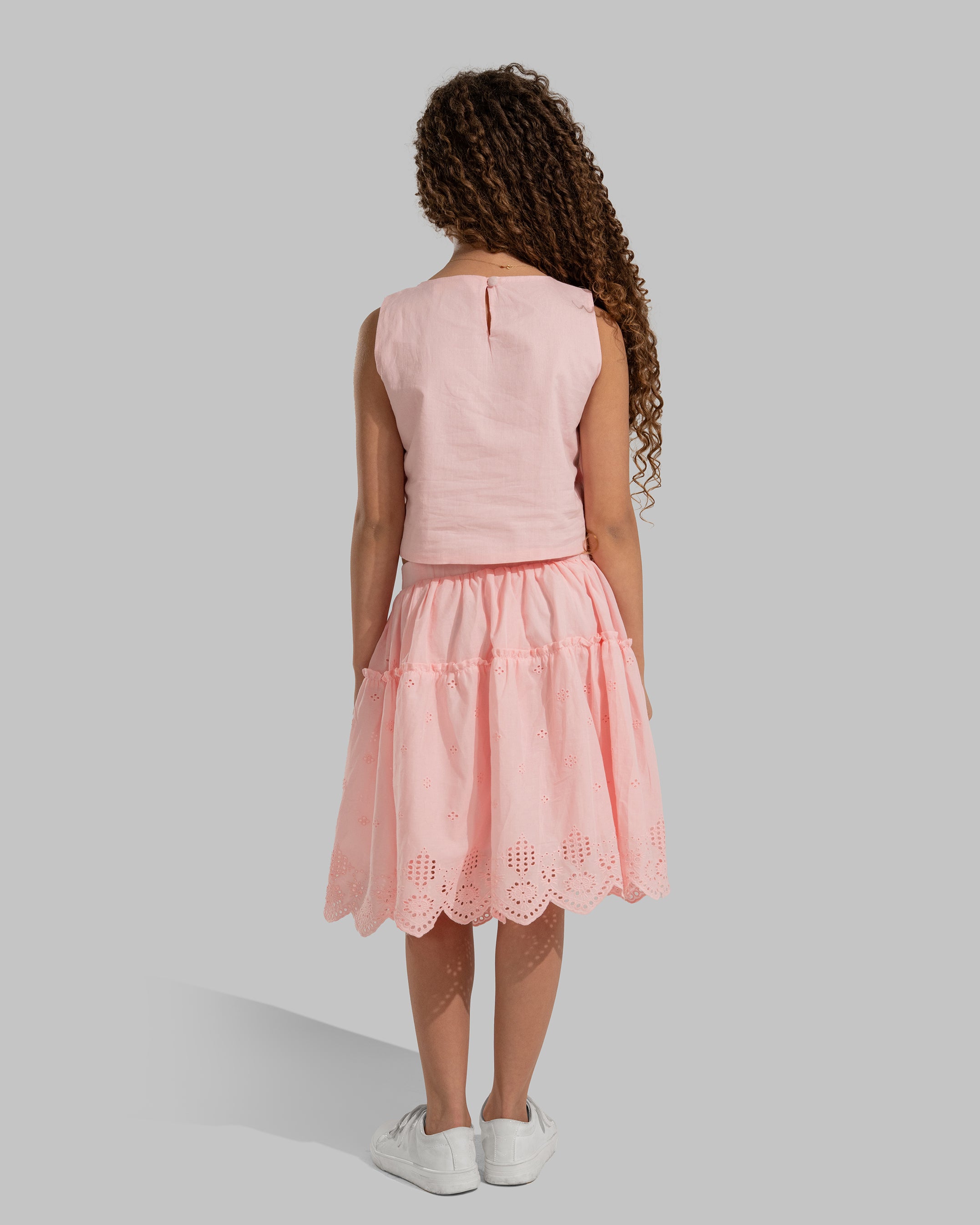 Sleeveless round neck top featuring decorative bows on the sides.
