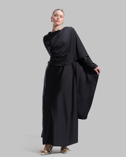 Long draped dress with a round neckline and asymmetrical overlay detail.