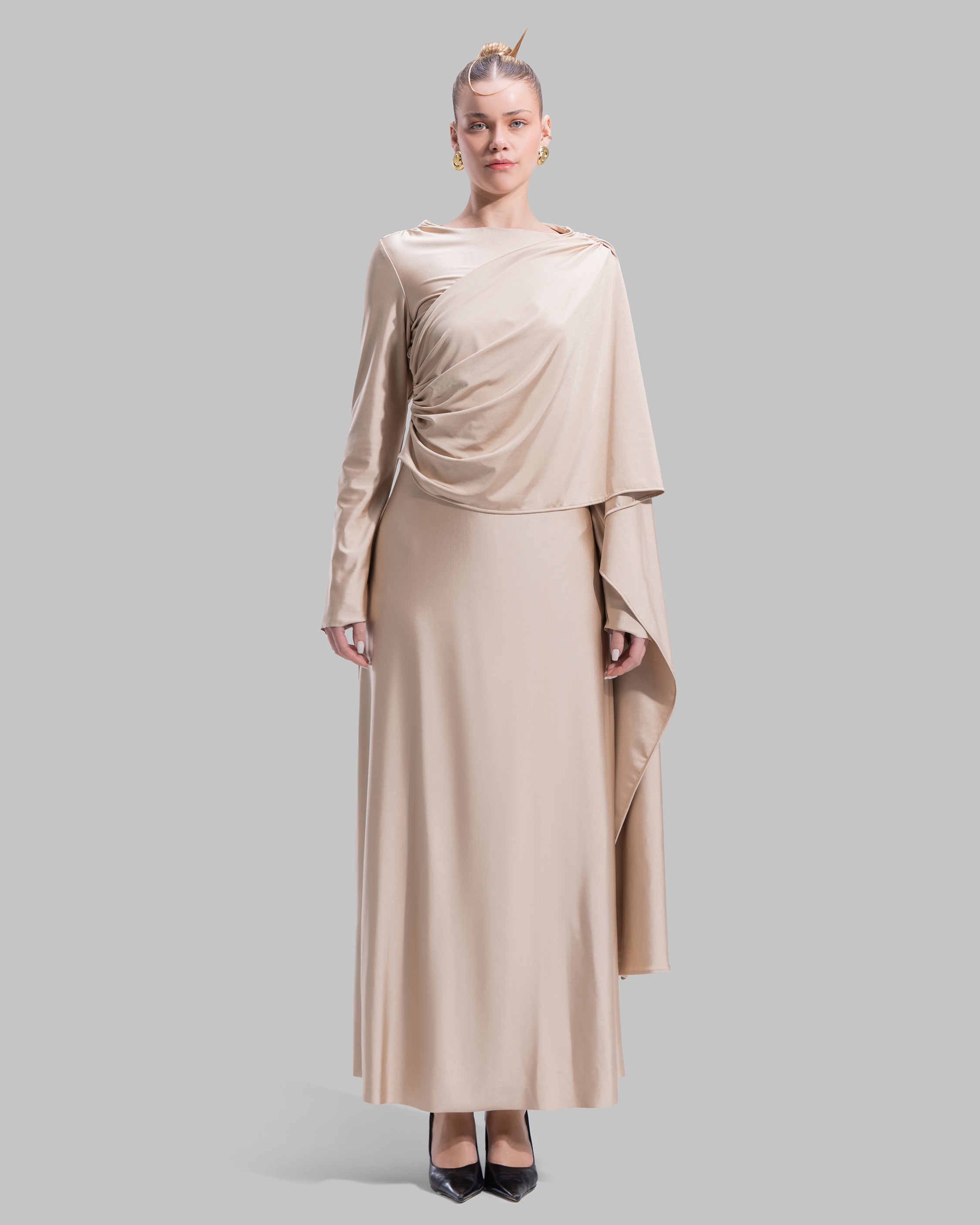 Long draped dress with a round neckline and asymmetrical overlay detail.