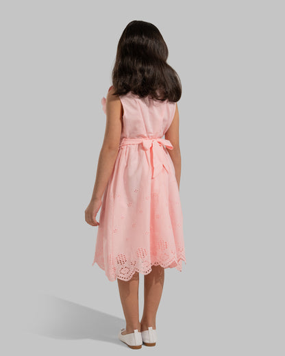 sleeveless pink cotton eyelet dress featuring a floral appliqué on the chest and a matching waist belt.