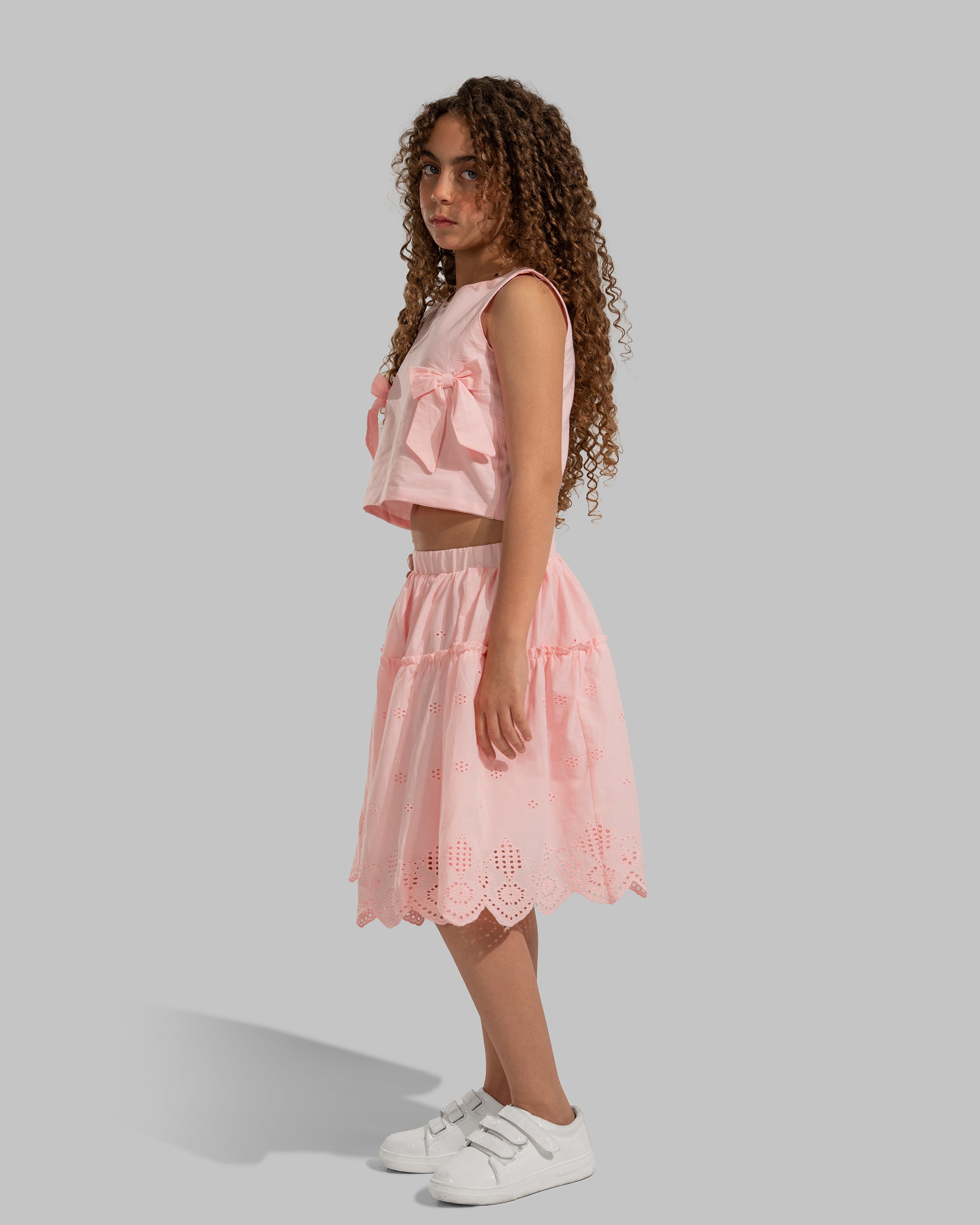 Sleeveless round neck top featuring decorative bows on the sides.